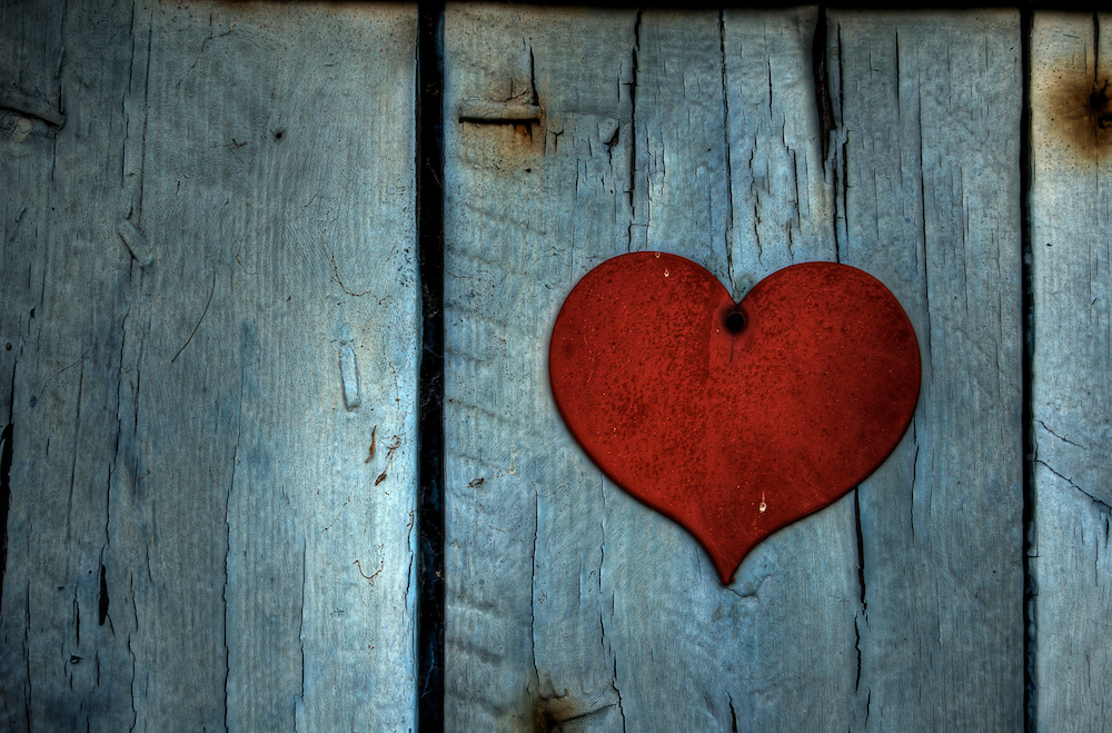 red metal heart on wood background